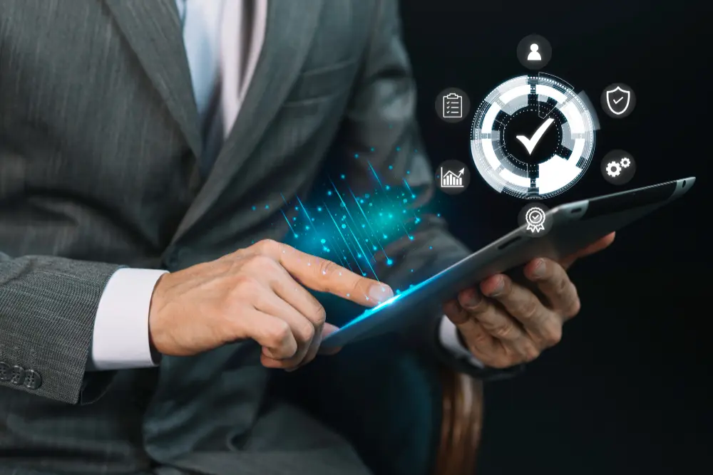 A graphic showing a man holding a tablet with digital effects showing a wheel and checkmark and other statistics displayed.